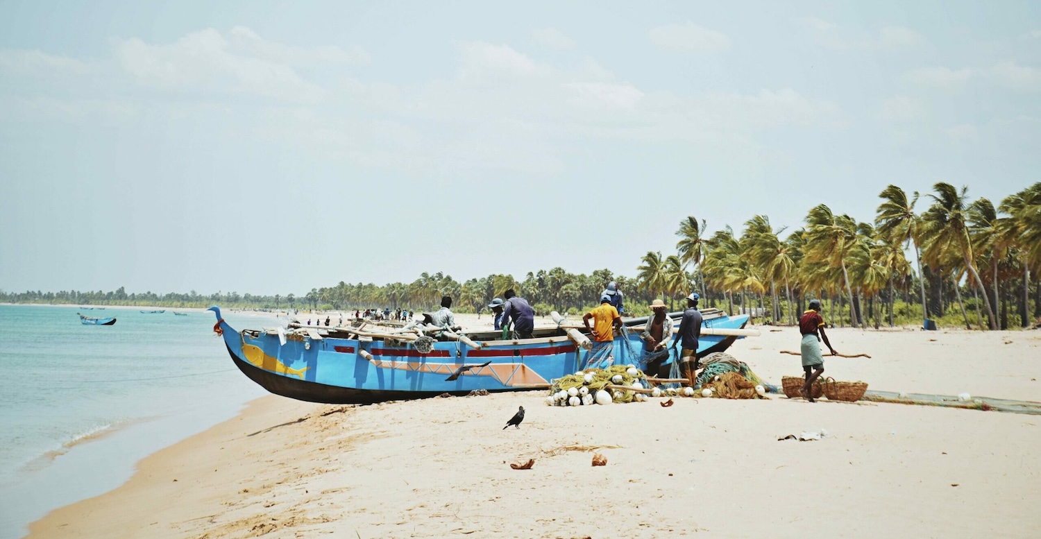 Fishermen on the shore with a boat