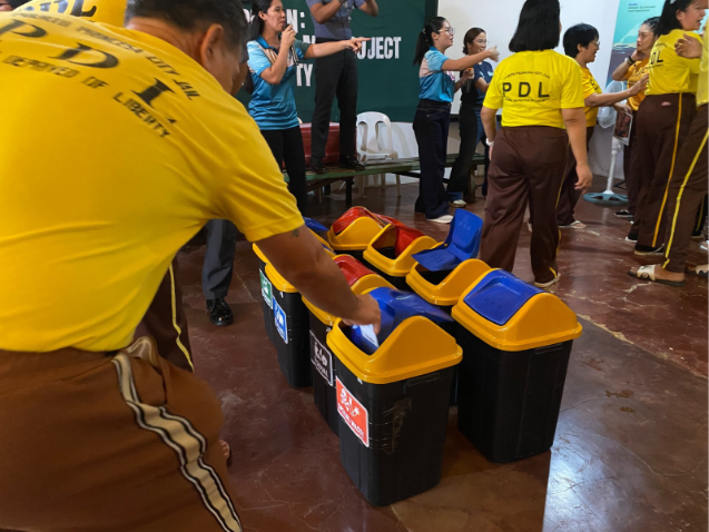 Seseorang yang membuang sampah ke dalam tempat sampah.